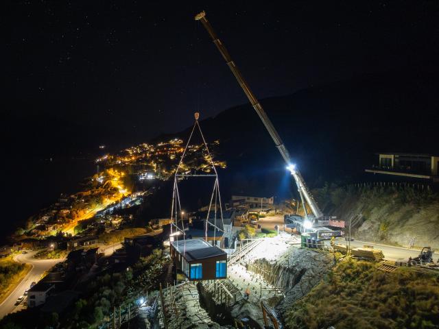 A home prebuilt in Christchurch is craned on to a steep Queenstown section at nighttime recently....