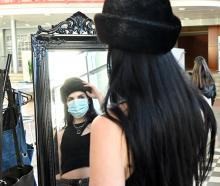 Stallholder and Otago Polytechnic student Geo Castle tries on a vintage fur hat at her stall....