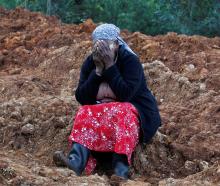 Esther Kinyanjui sits near the search and rescue operations for people feared trapped by...