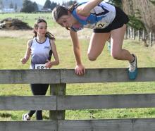 Queens runner Kotomiyo Cowell, 15, jumps a fence.


