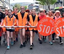 School traffic patrol team members are all smiles as they parade along George St dressed in...
