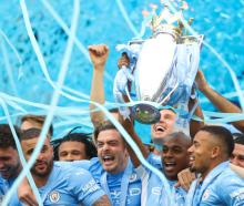Fernandinho of Manchester City lifts the Premier League trophy following their win against Aston...
