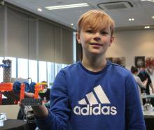 Ryan Howden proudly shows the robot he built as part of the workshop ‘‘Build your own robot! —...