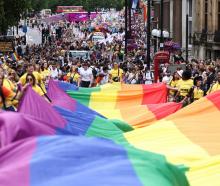 A large rainbow flag is carried along a central London street. Photo: Reuters 