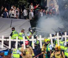 Police and firefighters clear protesters as tents burned on Parliament's lawns. Photo: Mike Scott