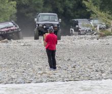 A protester from the Ashley Rakahuri Rivercare Group stands in front of 4WDs racing down the...