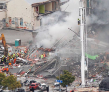 Firefighters, police and other search and rescue crews at work on the collapsed and burning CTV...