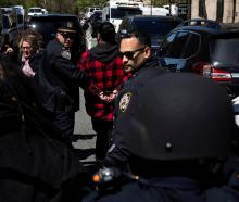 A demonstrator is detained by police officers outside Columbia University's New York City campus....