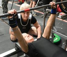 Nicola Atwool (70) warms up for her first weightlifting competition, spotted by partner Lesley...