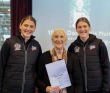 Dame Lois Muir is presented her Netball New Zealand service award by Silver Ferns Georgia (left)...