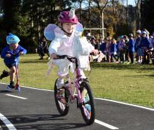 Abbotsford School pupil Ivy Robinson, 5, effortlessly cycles around a new track while fellow...