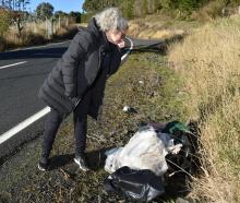 Concord resident Fiona Nicholson  holds her nose yesterday over a bag  containing a carcass...