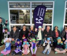 Women Helping Ōtepoti members and friends mix with Karitāne School pupils who are wearing knitted...
