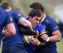 Taieri’s Josh Whaanga is wrapped up by Dunedin’s Joe Cook (left) and Hame Toma during their match...