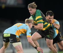 Green Island wing Michael Manson is sandwiched by University defenders Finlay Hagen (left) and...