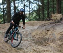 Christening the fresh trail with his bike is Waikaia Trails Trust member Sam Ruddenklau. PHOTO:...