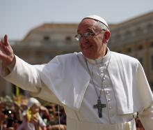 Pope Francis waves to the crowds during a drive around St. Peter's Square during Palm Sunday Mass...