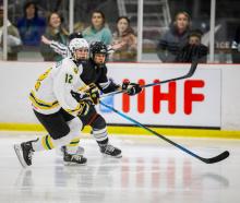 Australian ice hockey player Lily Roberts (left) and New Zealand’s Katya Blong chase the puck...