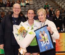 Kristie Simpson (centre) celebrates her 150th game with long-serving umpire support Kirsten Lloyd...