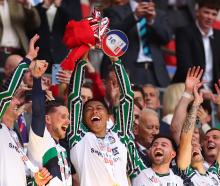 Jobe Bellingham of Sunderland lifts the trophy and celebrates promotion to the Premier League...