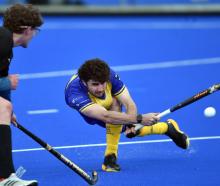 Taieri Tuataras player James Nicolson gives it a good whack while watched by University Panthers...