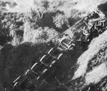 A derailed AB steam locomotive and its tender lie upside down in a gully at Kakahi near...