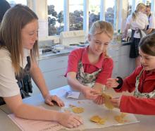 East Otago High School student Arabella Hagan (left) helps Palmerston School pupils Ivy Higgins...