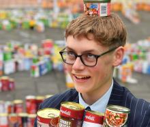 King’s High School student Gregor Watts, 15, displays some of the 3685 cans collected by his...