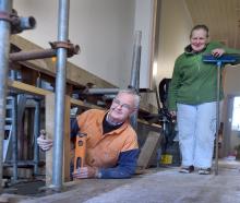 South Dunedin resident Marion McManus watches as builder Ken Close continues lifting the...