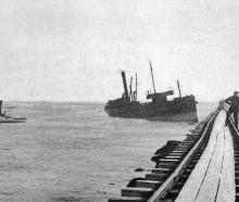 Steamship Storm lies against the Castlecliff mole at Whanganui on October 10, 1925, near the...