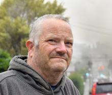 Veteran scout leader Shaun Adie, on School St ,with the Roslyn Scout Hall blowing pools of smoke...