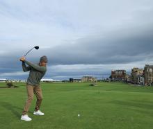 World surfing champion Kelly Slater tees off on the 18th hole at St Andrews during the Alfred...