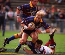 Highlanders winger Jeff Wilson has flanker Paul Henderson in support as he tries to elude Reds...