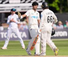New Zealand's Rachin Ravindra celebrates with Tom Blundell after reaching his century against...