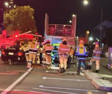 Firefighters work to free a 39-year-old man who crashed his car into the back of a parked logging...
