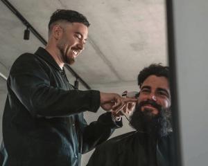Cut above: Point Cut Barbershop coowner and barber Remmy Kumar with client Ollie Mark.