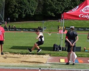 Big jump . . . Harry Houghton, 8, from the Gore Athletics Club, competes in the long jump at the...