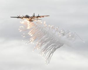 An RNZAF Hercules does a flare dump over Lake Wānaka.