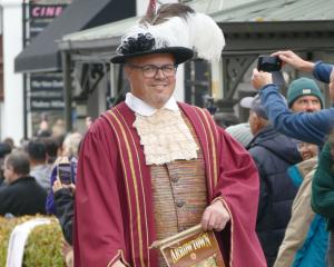 Town crier Dougal MacPherson leads the Arrowtown Autumn Festival Street Parade down Buckingham St...