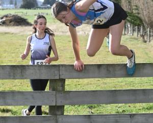 Queens runner Kotomiyo Cowell, 15, jumps a fence.


