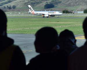 A crowd watch the first Jetstar flight from the Gold Coast to land at Dunedin Airport yesterday....