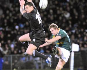 New Zealand's Dan Carter, left attempts to stop a drop goal from South Africa's Butch James....