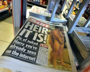 A copy of The Sun newspaper featuring a picture of a naked Prince Harry is seen in a shop in...