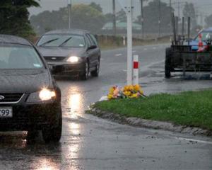 A guard of police officers stand to attention as two hearses carry away the bodies of victims...