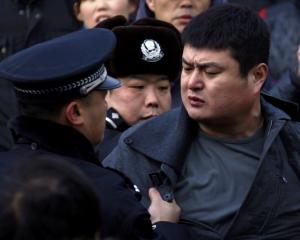 A man is dragged away by the police after he refused to leave the front of the Apple store in the...