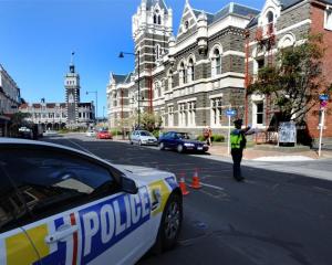 A police officer diverts traffic away from the Dunedin court house yesterday. Photos by Staff...