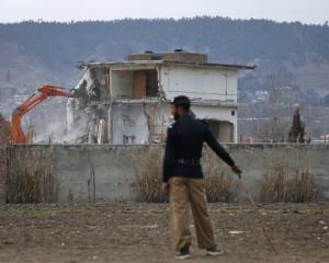 A policeman looks on as the building where al Qaeda leader Osama bin Laden was killed is...