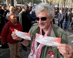A Rolling Stones fan displays two tickets he purchased for a short warm-up gig in Paris. REUTERS...