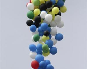 A South African balloonist floats above the sea using helium-filled balloons. Photo by Reuters.