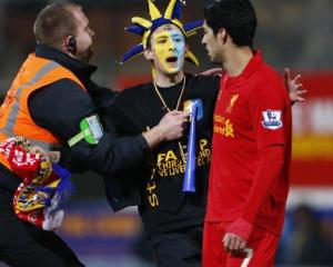 A steward prevents a Mansfield Town supporter from reaching Liverpool's Luis Suarez (R) during...